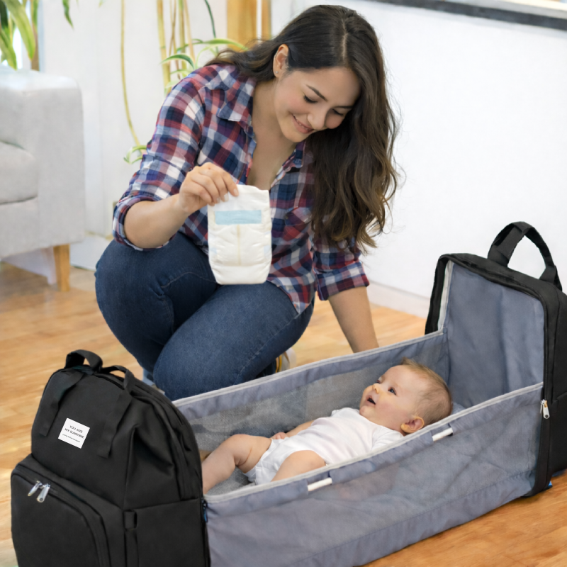 Mamá mudando al bebé dentro de la mochila con la malla visible